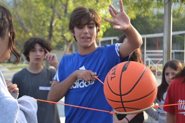 Participantes de campamento en dinámicas al aire libre, promoviendo el respeto y la responsabilidad con el entorno.