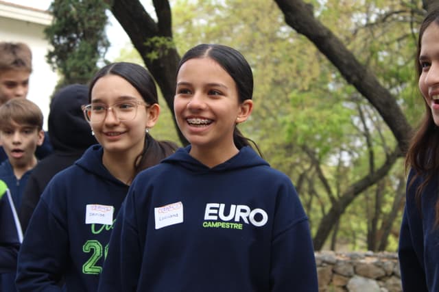 Niños interactuando en la naturaleza, explorando el medio ambiente y aprendiendo sobre la importancia de cuidarlo.