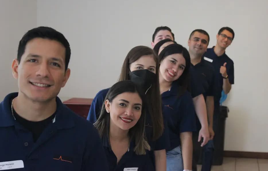 Grupo de profesionales de ALYAX posando juntos con uniformes azules, reflejando confianza, profesionalismo y unidad