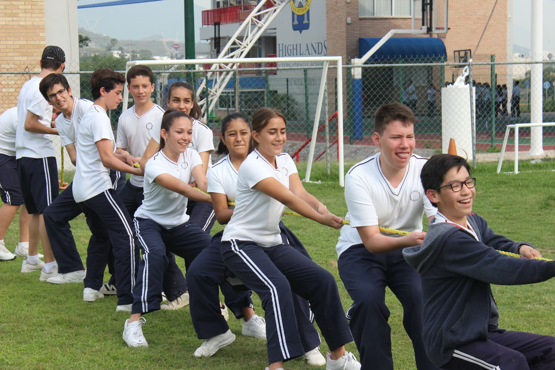 Colaboradores de ALYAX participando en una competencia de soga en un espacio abierto, resaltando el trabajo en equipo