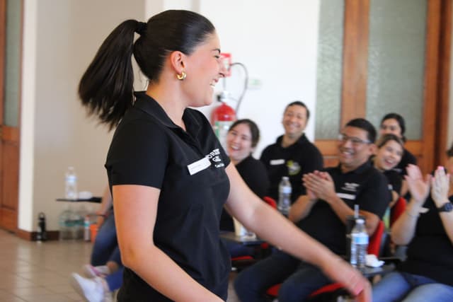 Mujer concentrada en una actividad práctica, destacando la importancia de la escucha activa en el desarrollo de liderazgo