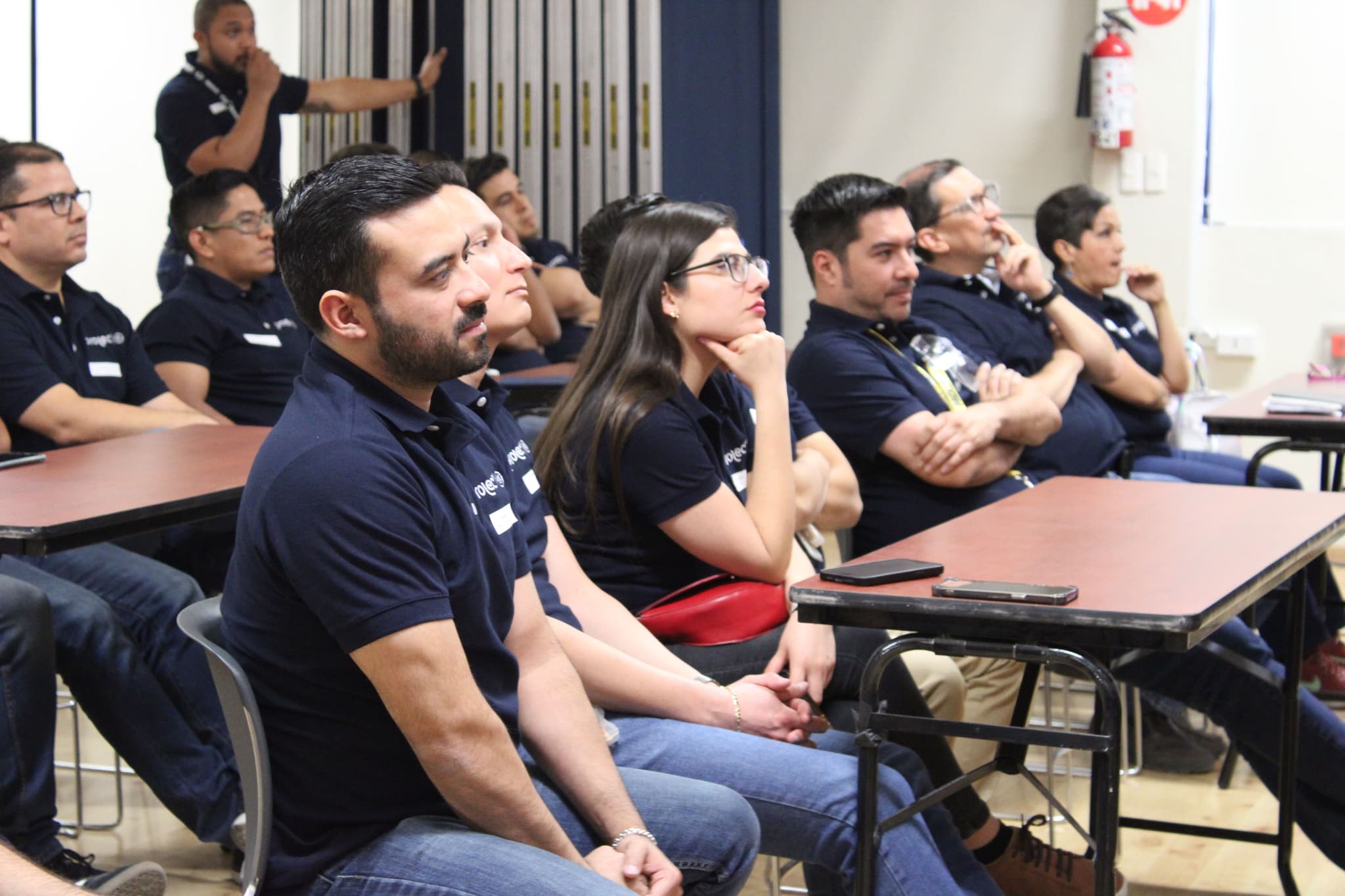 Participantes atentos durante una actividad, aprendiendo a aplicar habilidades de liderazgo en sus proyectos empresariales