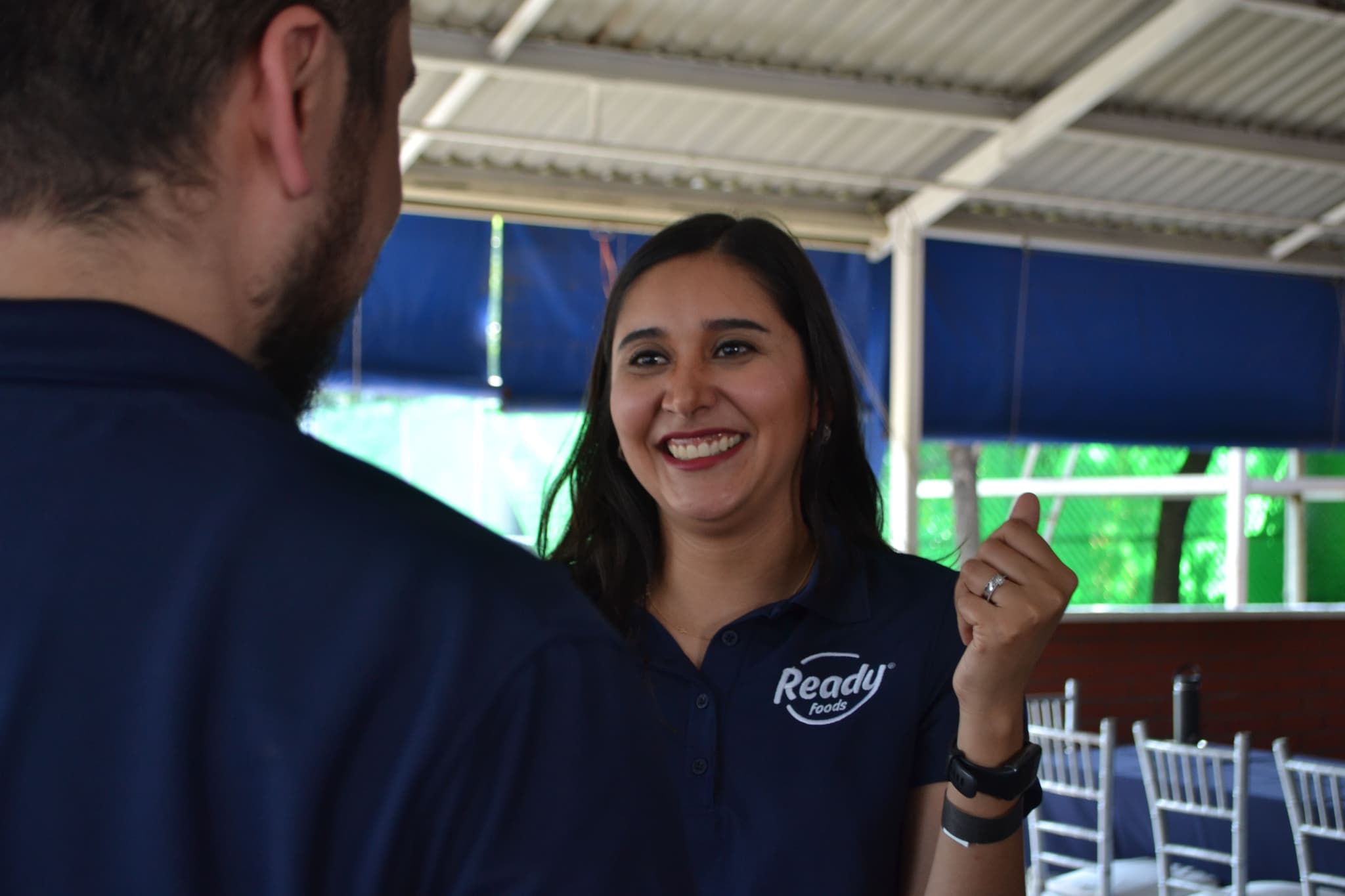 Mujer sonriente en una sesión de trabajo grupal, mostrando entusiasmo por formar parte de un equipo comprometido