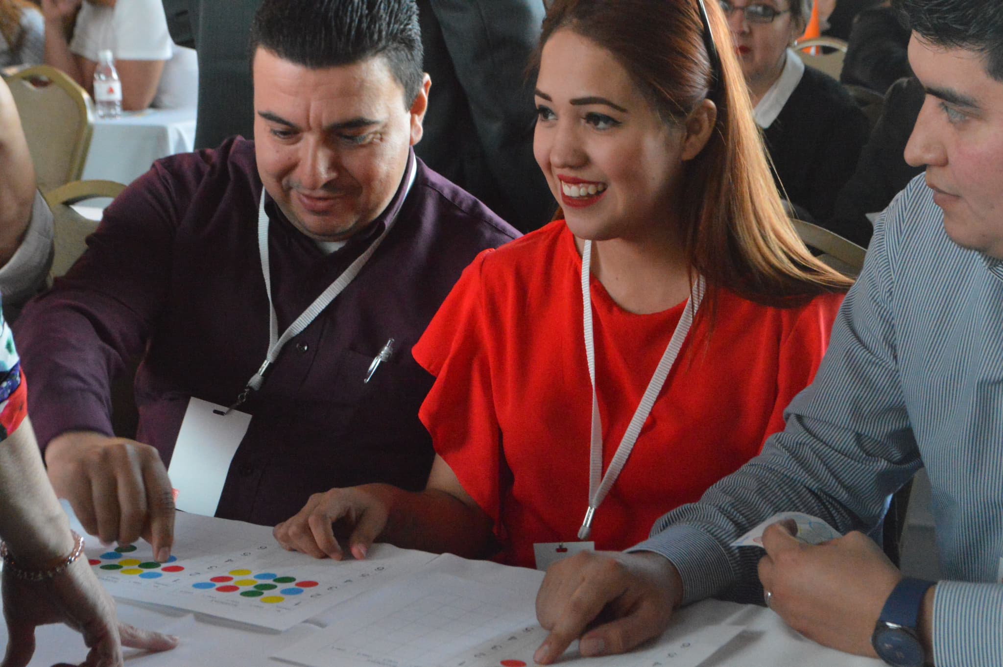 Profesionales interactuando durante una actividad en interiores, compartiendo ideas para alcanzar objetivos comunes