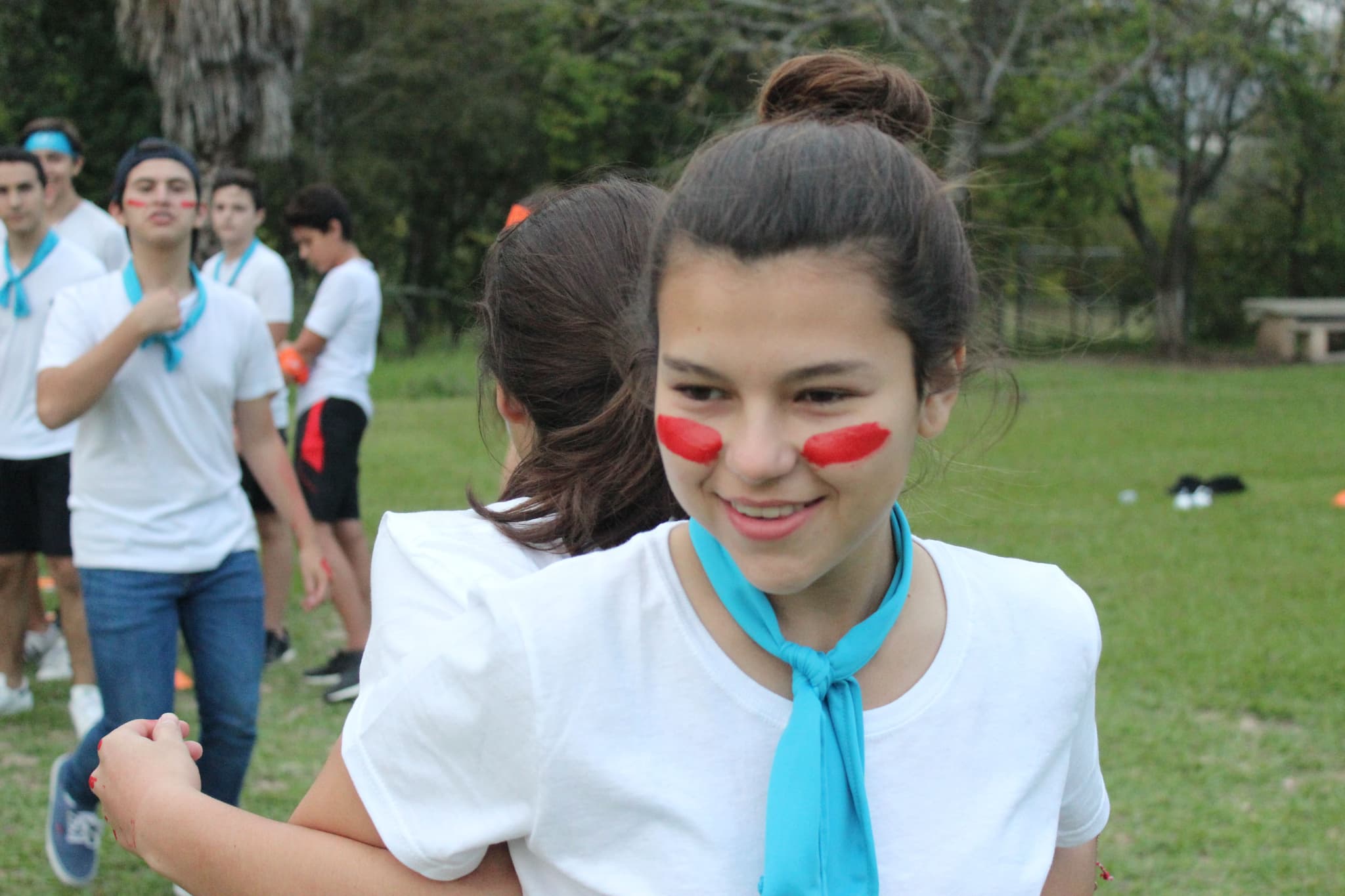 Estudiante con pintura en el rostro participando activamente en una dinámica, destacando la energía del evento