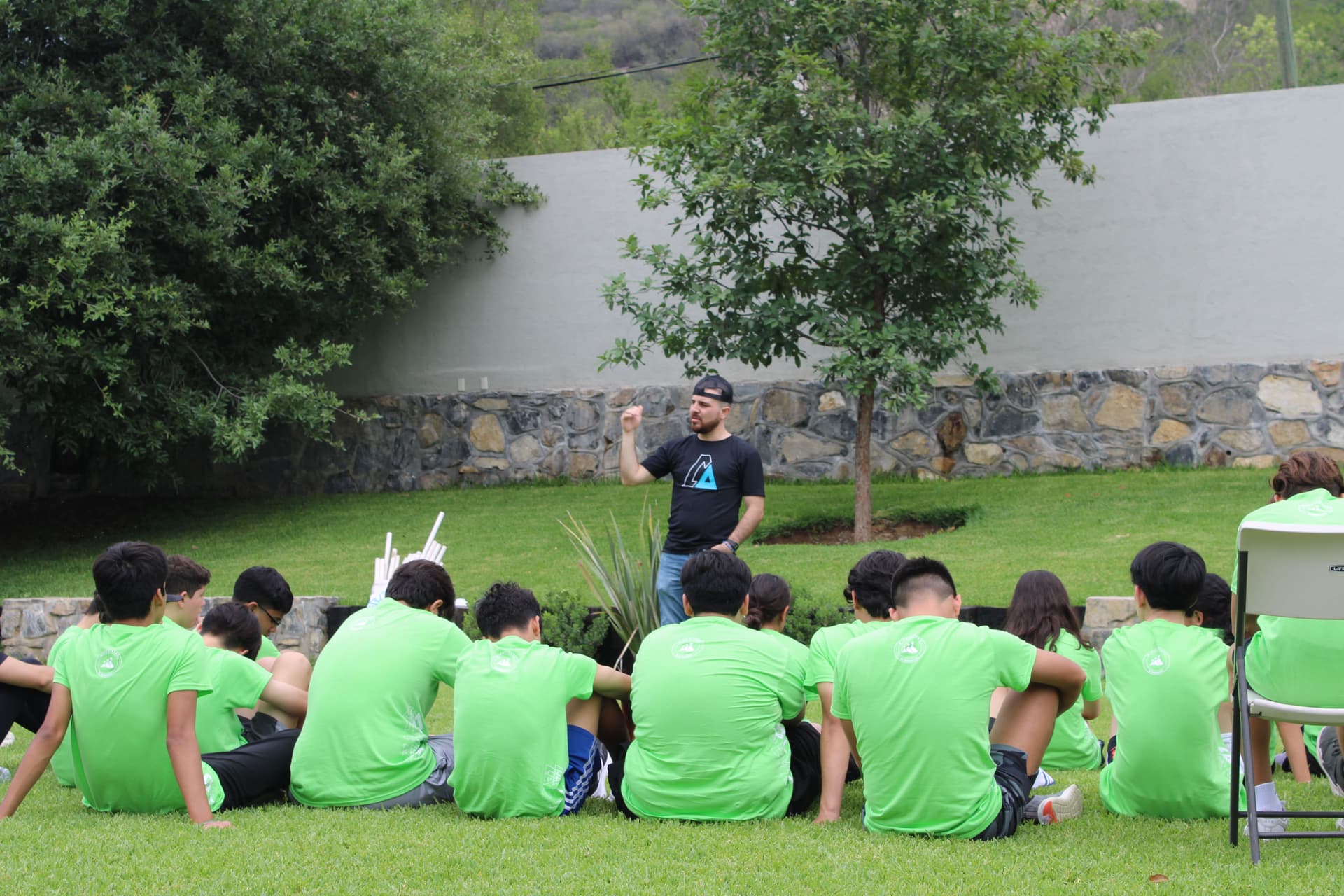 Facilitador motivando a los estudiantes en un espacio abierto, destacando la importancia de la integración escolar