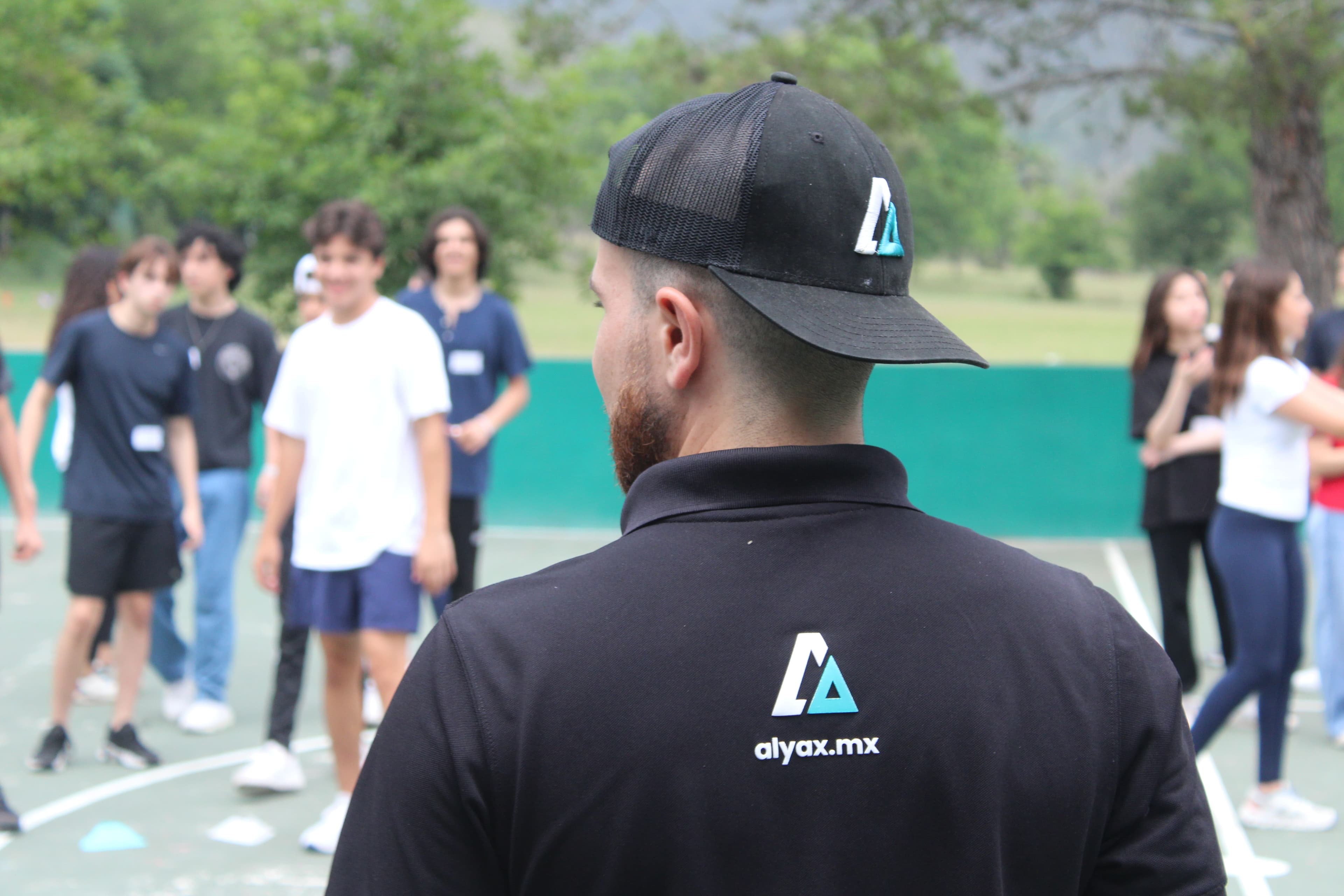 Facilitador de ALYAX observando mientras un grupo de alumnos participa en una actividad al aire libre.