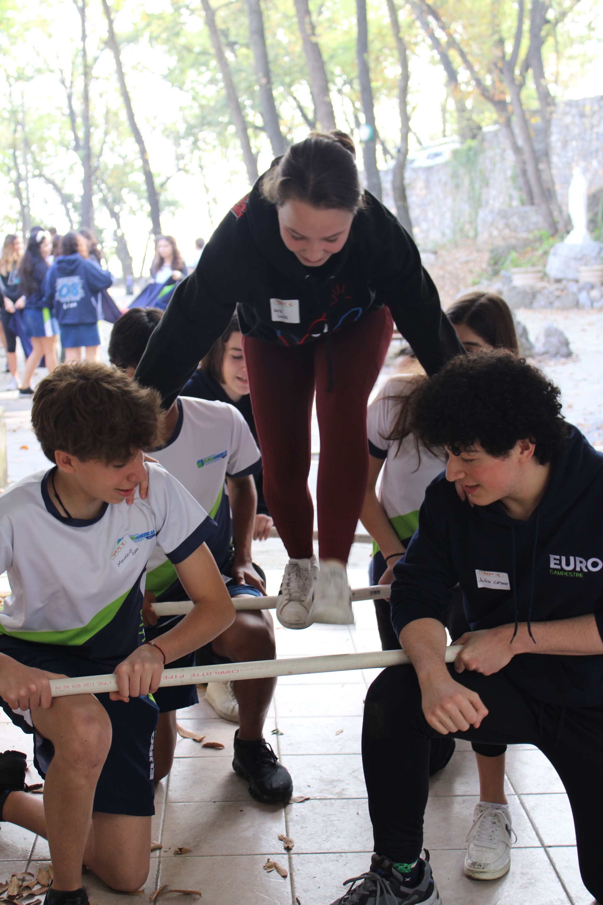 Participantes trabajando juntos durante una actividad al aire libre, desarrollando confianza y comunicación