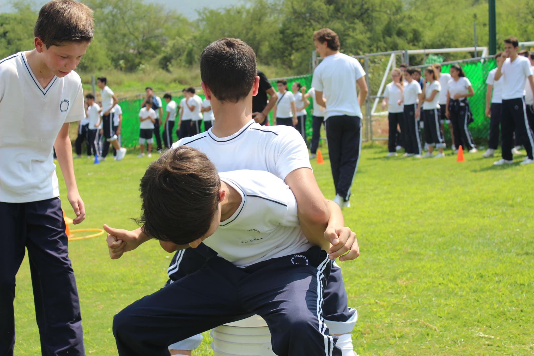 Grupo de alumnos escuchando atentamente las instrucciones de un facilitador antes de iniciar una dinámica de integración