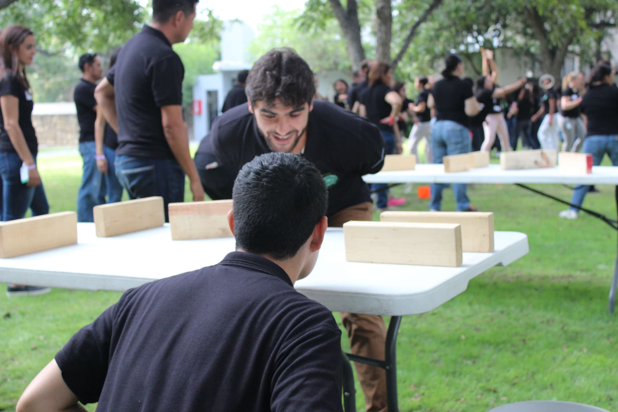 Grupo de docentes trabajando juntos en una actividad creativa en exteriores, mostrando comunicación y colaboración