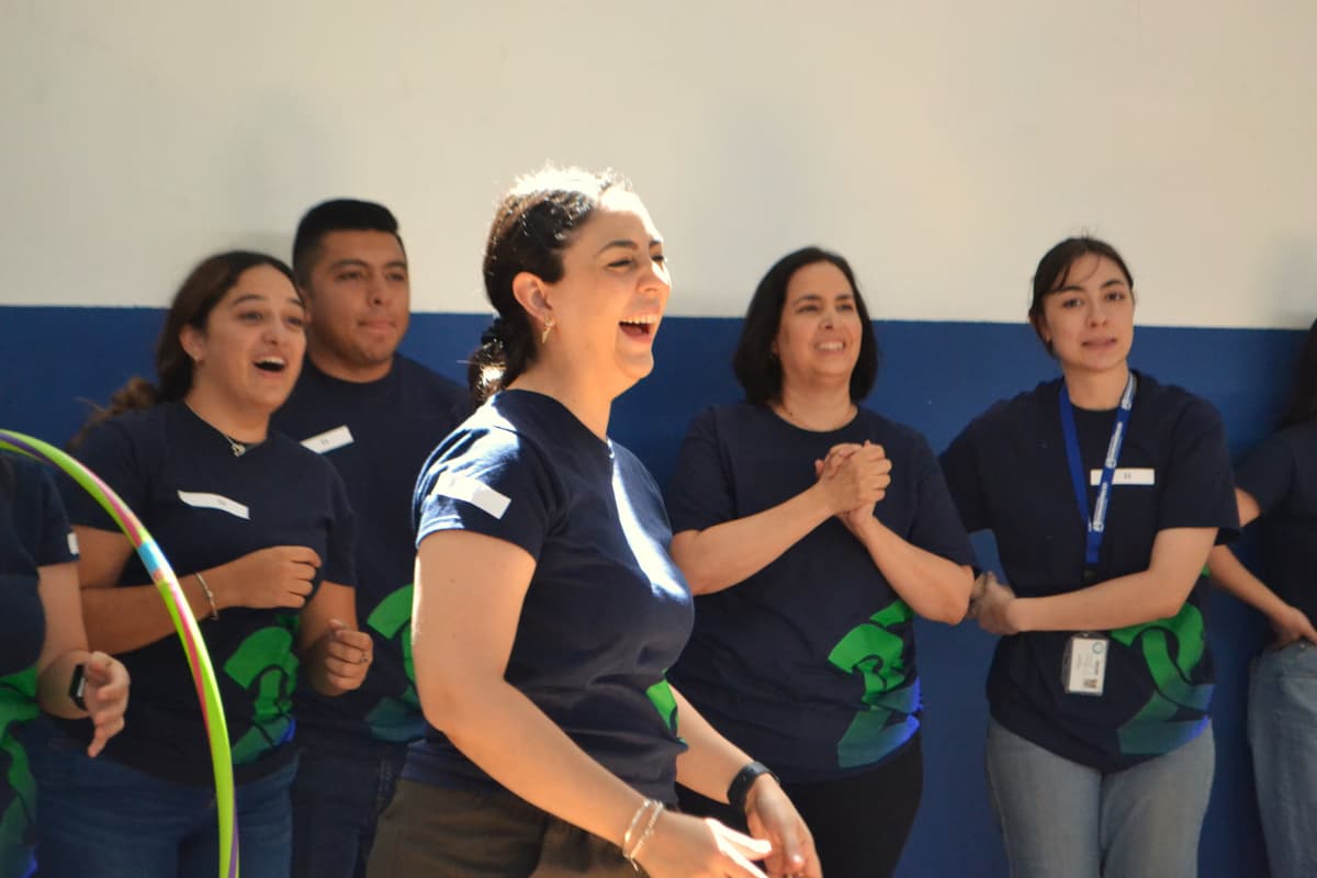 Docente expresando entusiasmo durante una dinámica grupal, reflejando el impacto positivo de las actividades de integración