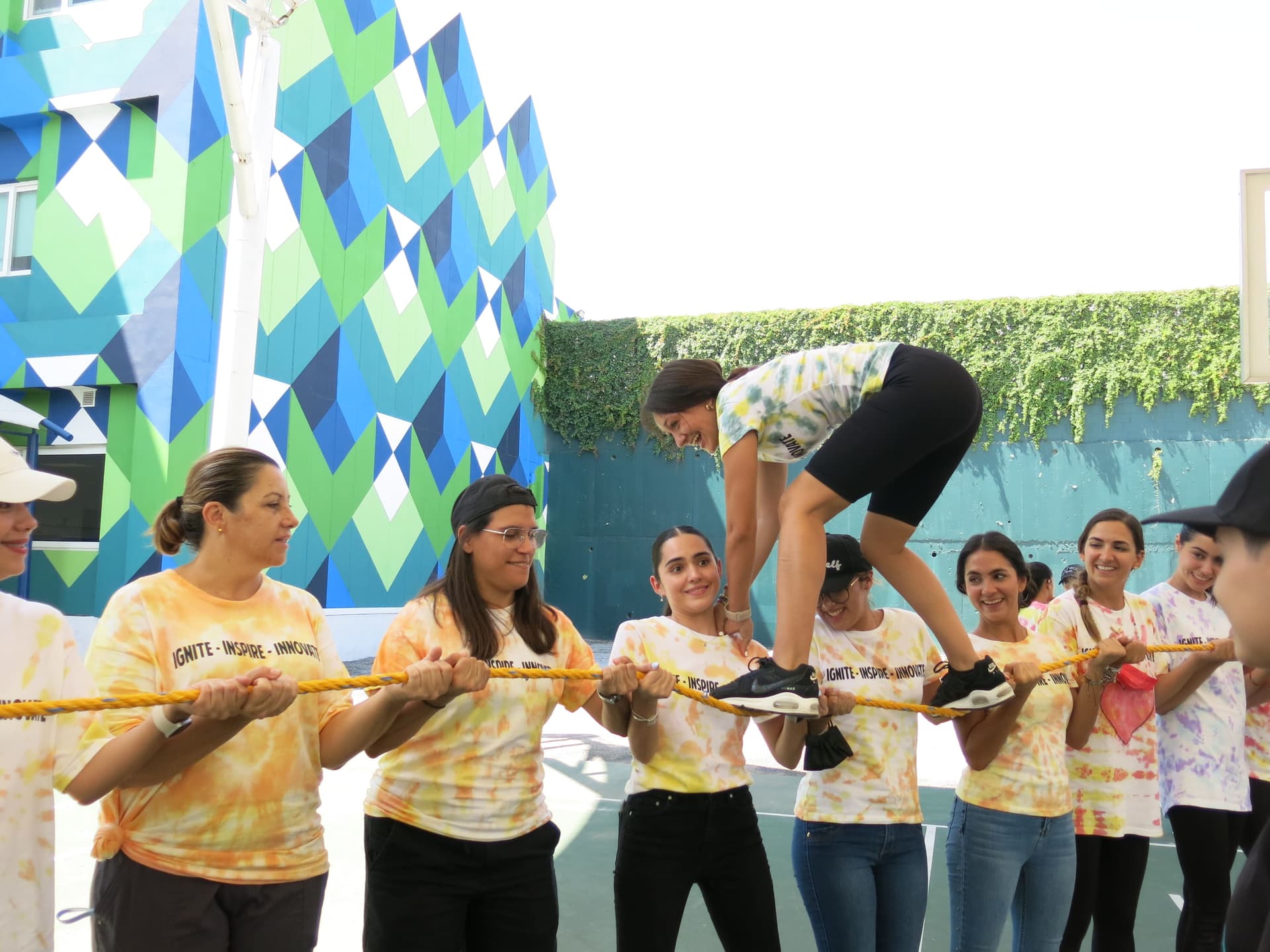 Docentes trabajando juntos en un reto físico al aire libre, demostrando compromiso y trabajo en equipo