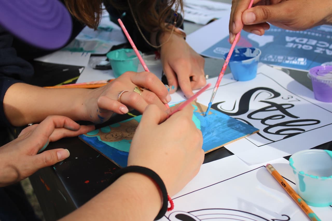 Manos colaborando en un proyecto creativo, mostrando cómo el trabajo en equipo fomenta la innovación y la ejecución exitosa