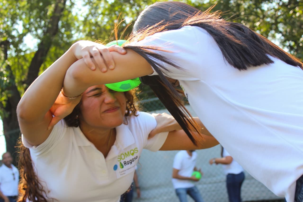 Docente participando en una dinámica con los ojos vendados, demostrando la importancia de la confianza en las relaciones laborales