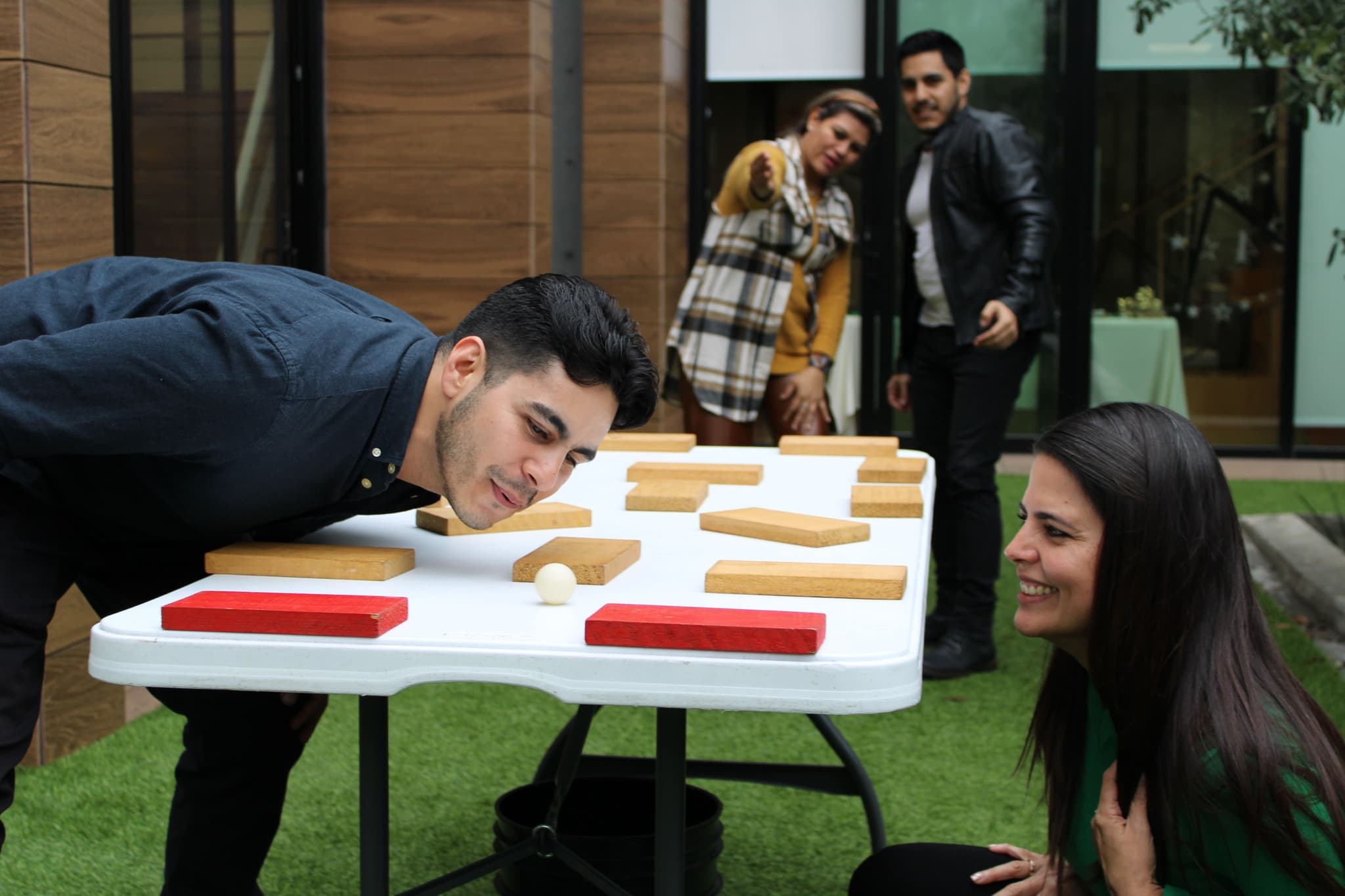 Participantes construyendo estructuras de madera, simbolizando la planificación y el trabajo coordinado en equipo