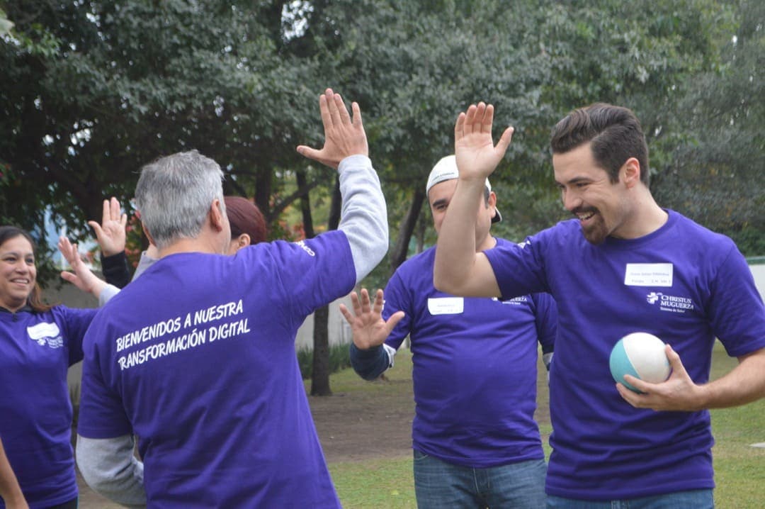 Participantes chocando las manos en señal de celebración, destacando el éxito alcanzado como equipo