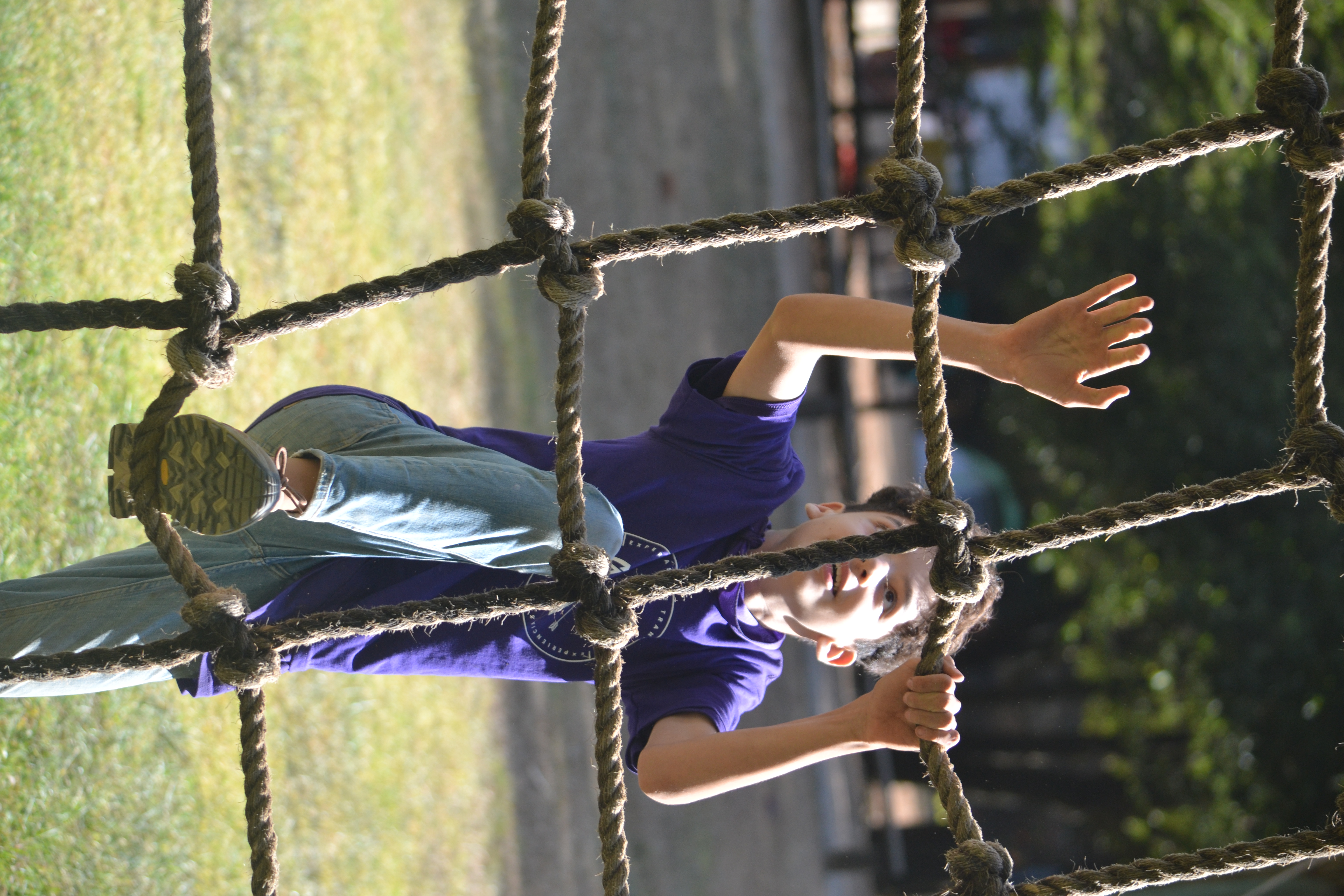 Niño lanzando un aro en un reto al aire libre, mostrando la emoción y la diversión de las actividades del campamento