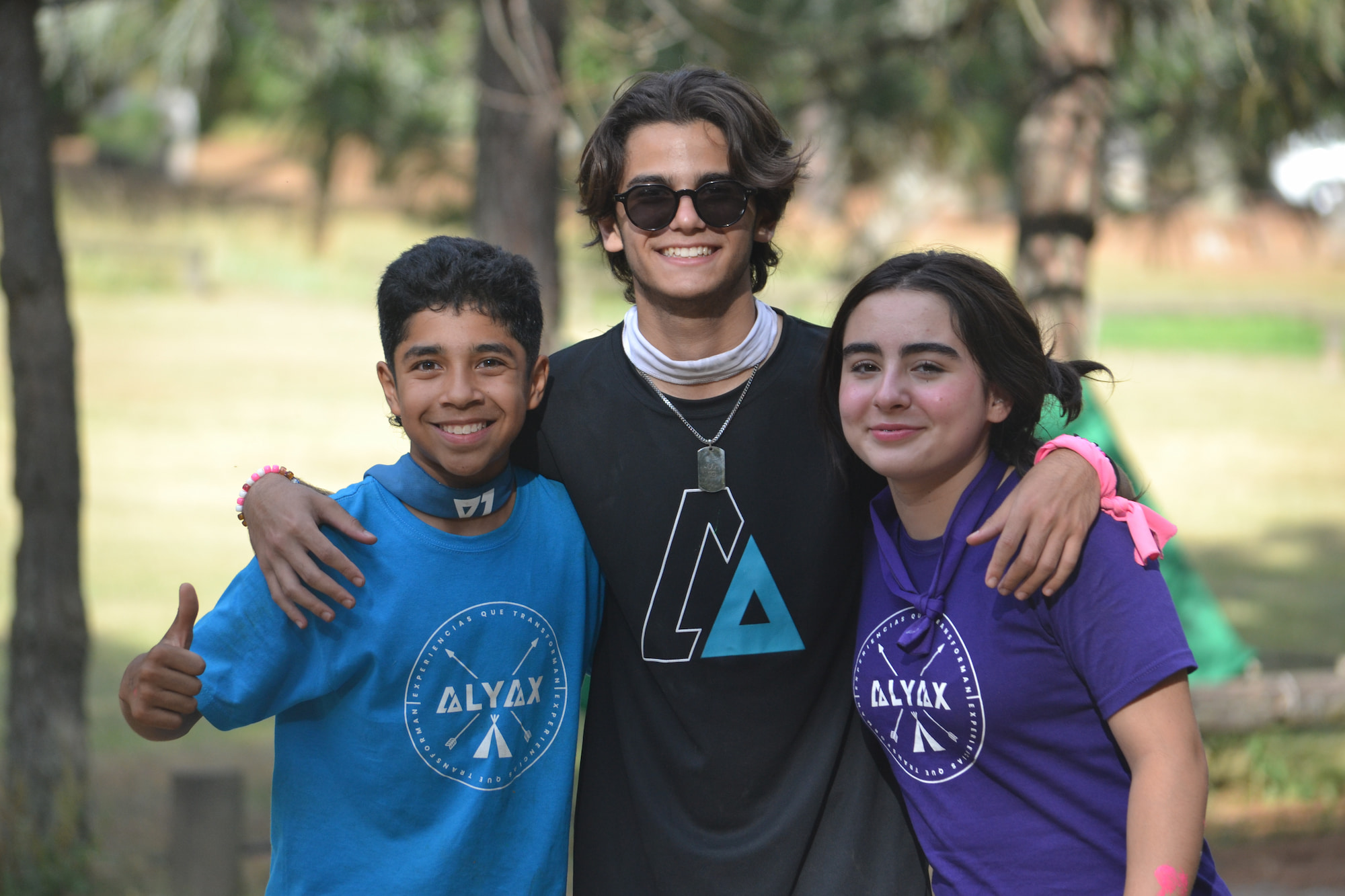 Foto grupal tomada desde abajo, con los niños formando un círculo y sonriendo, reflejando la amistad y la integración